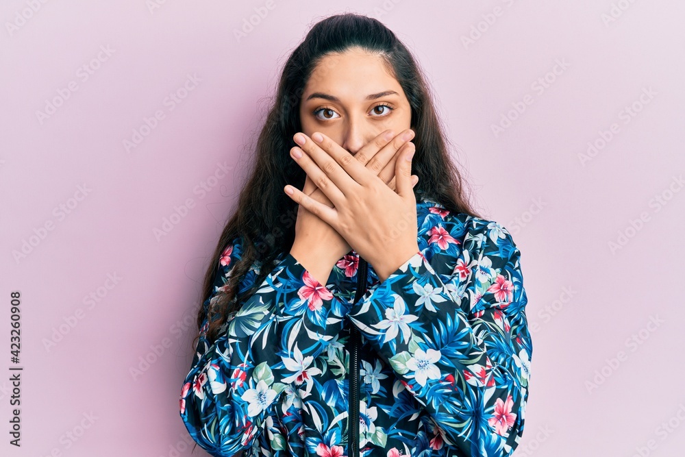 Beautiful middle eastern woman wearing casual floral jacket shocked covering mouth with hands for mistake. secret concept. Beautiful middle eastern woman wearing casual floral jacket shocked covering mouth with hands for mistake. secret concept.