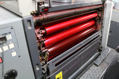 Red painted roller system of the printing machine in the printing house. Komori lithrone system. selective focus