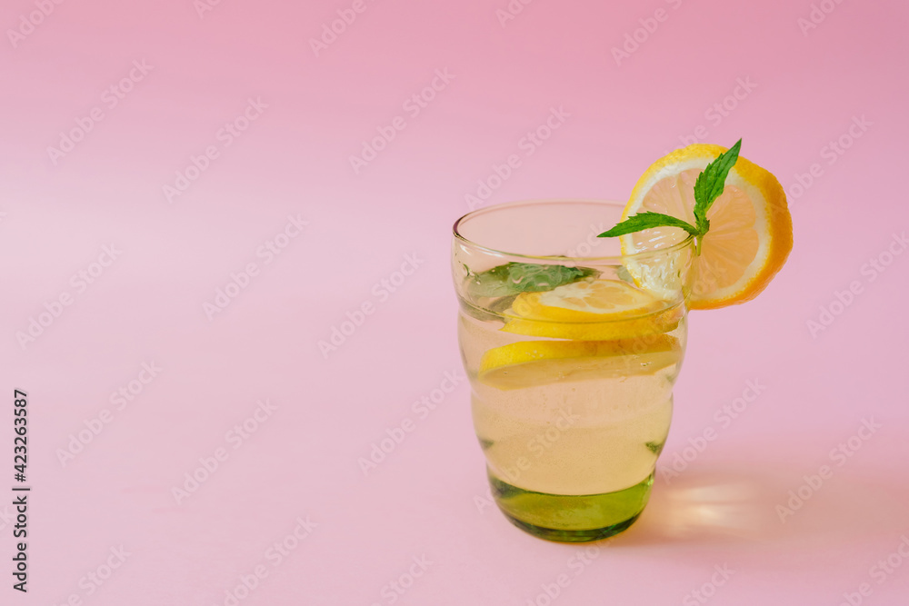 lemonade in a glass on a pink background. lemon and mint. vitamin charge, antioxidant. healthy life. fresh ingredients, diet beverage lemonade in a glass on a pink background. lemon and mint. vitamin charge, antioxidant. healthy life. fresh ingredients, diet beverage