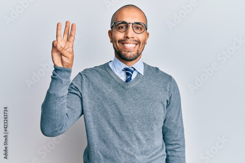 Hispanic adult man wearing glasses and business style showing and pointing up with fingers number three while smiling confident and happy. © Krakenimages.com