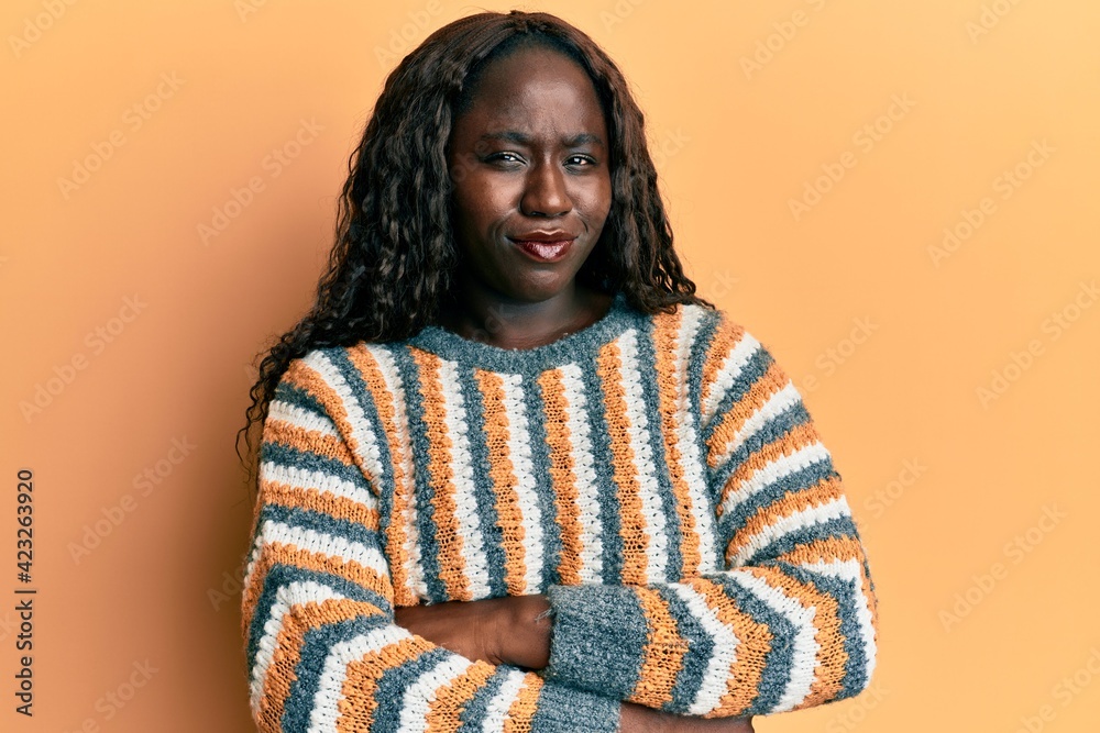 African young woman wearing wool winter sweater skeptic and nervous, disapproving expression on face with crossed arms. negative person. African young woman wearing wool winter sweater skeptic and nervous, disapproving expression on face with crossed arms. negative person.