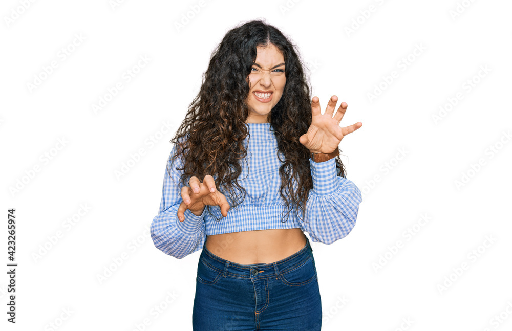 Young hispanic girl wearing casual clothes smiling funny doing claw gesture as cat, aggressive and sexy expression Young hispanic girl wearing casual clothes smiling funny doing claw gesture as cat, aggressive and sexy expression