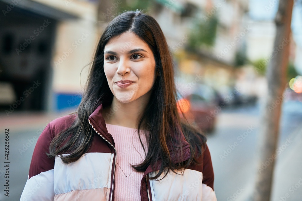 Fototapeta premium Young hispanic girl smiling happy standing at the city.
