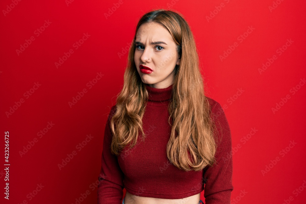 Young blonde woman wearing turtleneck sweater skeptic and nervous, frowning upset because of problem. negative person.