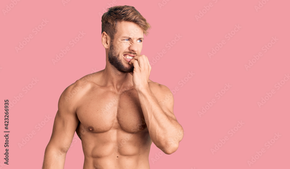 Fototapeta premium Young caucasian man standing shirtless looking stressed and nervous with hands on mouth biting nails. anxiety problem.