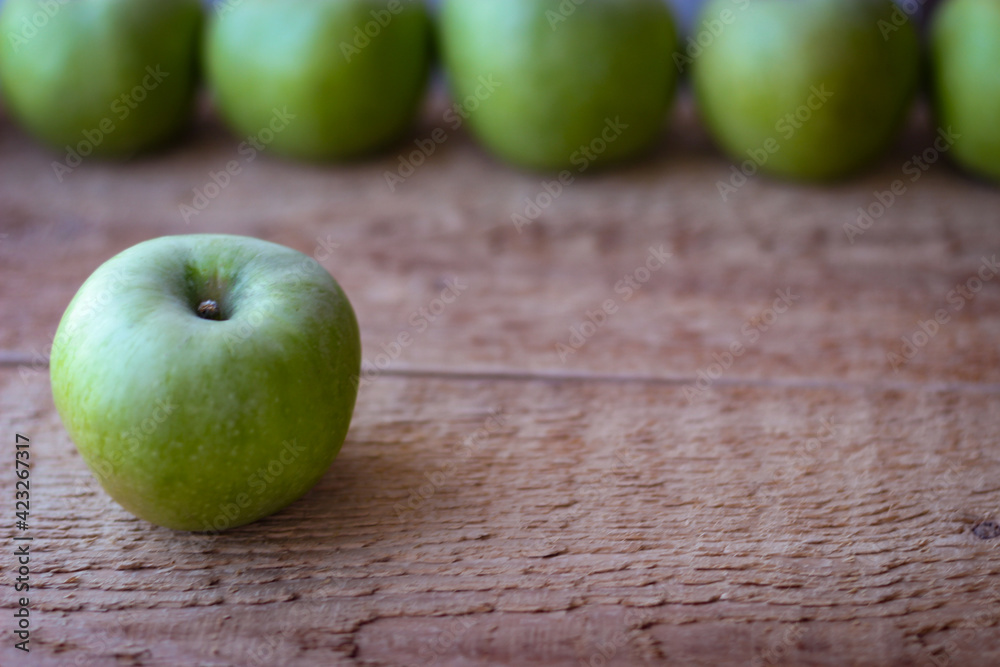 Green apples stand on a wooden surface Green apples stand on a wooden surface