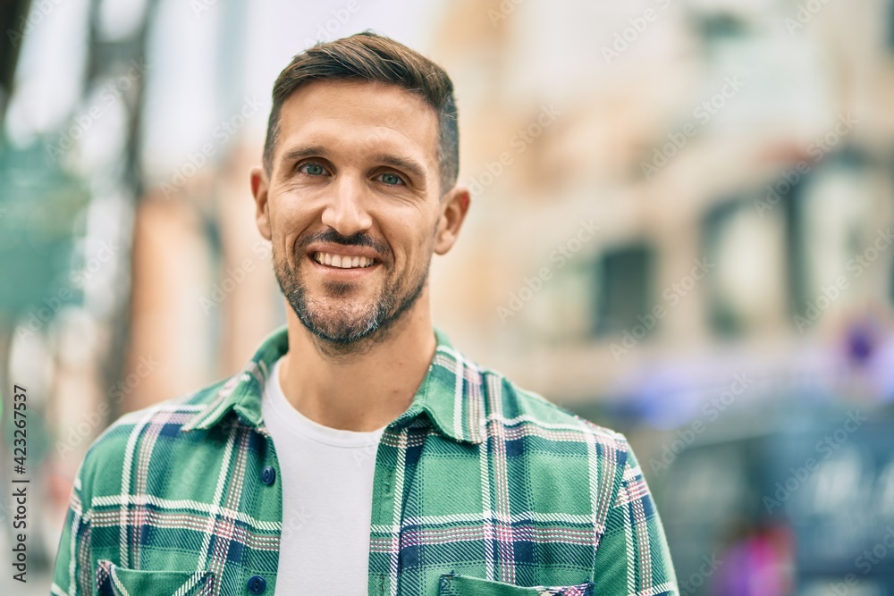Young caucasian man smiling happy standing at the city.