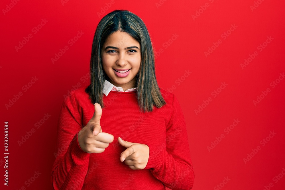 Young latin woman wearing casual clothes pointing fingers to camera with happy and funny face. good energy and vibes. Young latin woman wearing casual clothes pointing fingers to camera with happy and funny face. good energy and vibes.