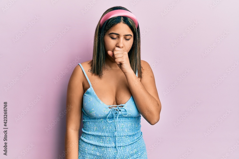 Young latin woman wearing summer clothes feeling unwell and coughing as symptom for cold or bronchitis. health care concept. Young latin woman wearing summer clothes feeling unwell and coughing as symptom for cold or bronchitis. health care concept.