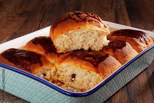 Fresh baked buns with chocolate filling in a ceramic oven tray.