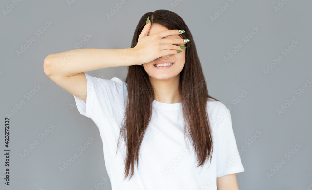 Happy woman closing eyes with hand going to see surprise prepared by boyfriend standing and smiling in anticipation for something wonderful. Young lady covering face with hand Happy woman closing eyes with hand going to see surprise prepared by boyfriend standing and smiling in anticipation for something wonderful. Young lady covering face with hand