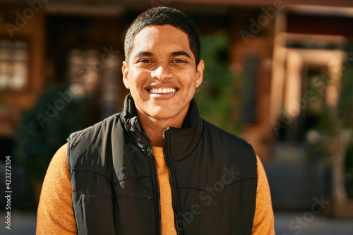 Young latin man smiling happy standing at the city