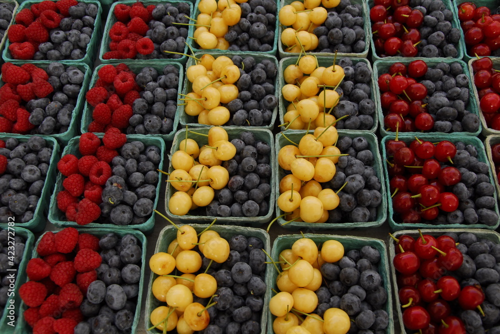 close shot of colorful boxes of cherries and mixed berries at farmers market, Portland, Maine close shot of colorful boxes of cherries and mixed berries at farmers market, Portland, Maine