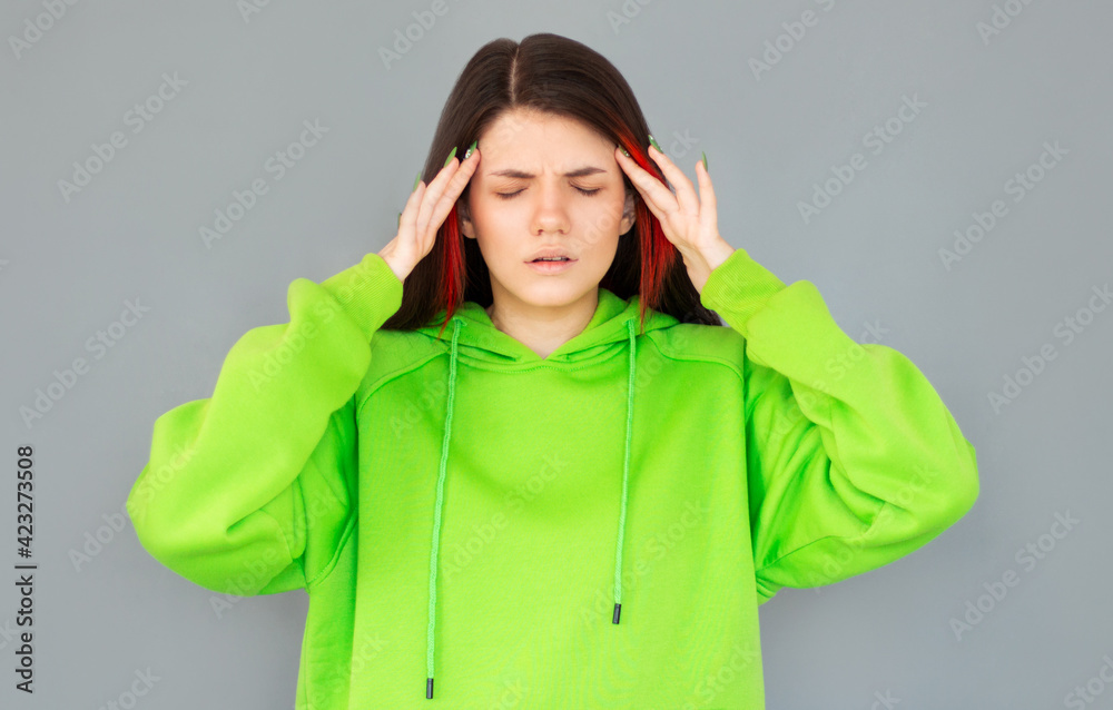 Young woman has headache isolated on gray background Young woman has headache isolated on gray background