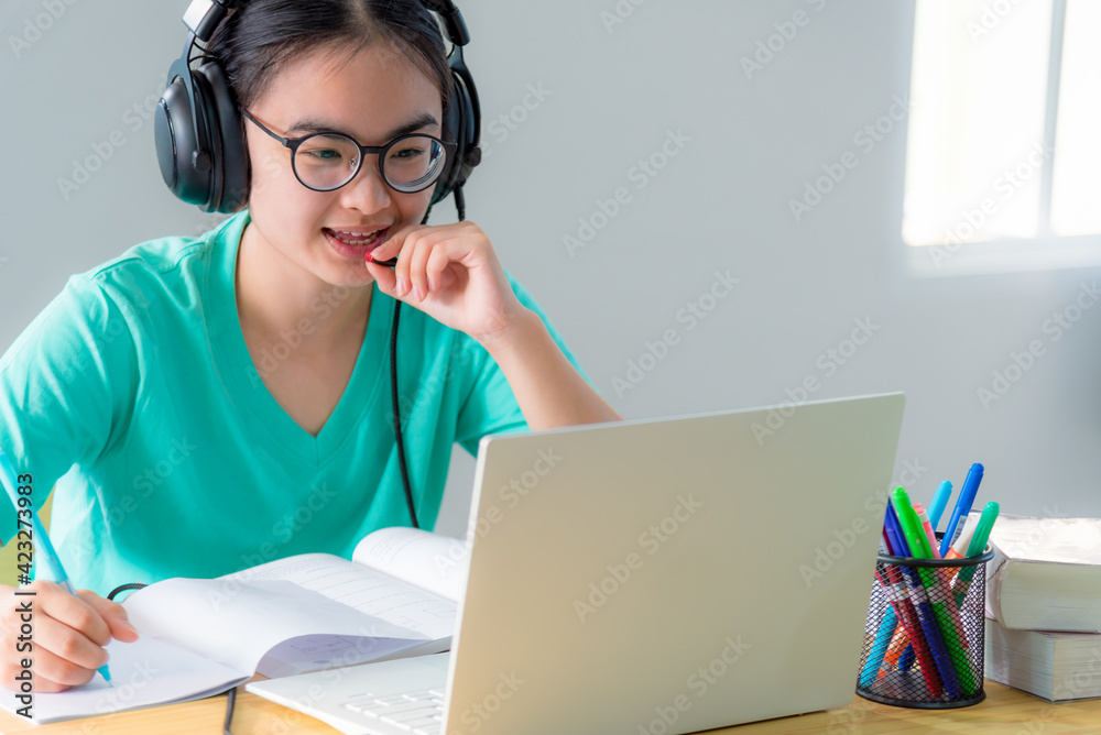 Asian woman looking to talk video conference calling on a laptop computer girl students speak respond with headset microphone class university learning internet online distance education from home Asian woman looking to talk video conference calling on a laptop computer girl students speak respond with headset microphone class university learning internet online distance education from home