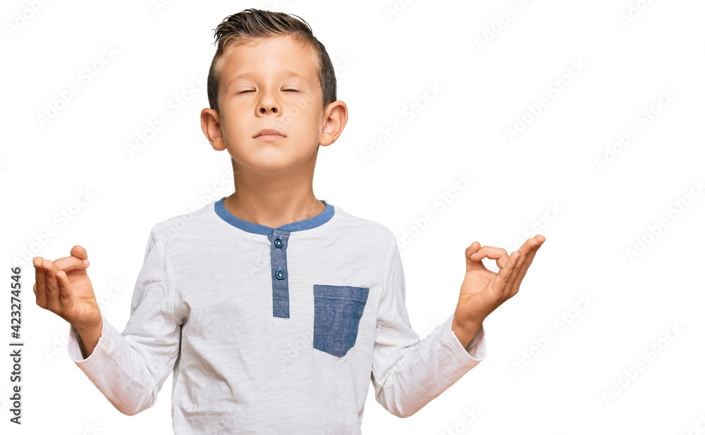 Adorable caucasian kid wearing casual clothes relax and smiling with eyes closed doing meditation gesture with fingers. yoga concept. Adorable caucasian kid wearing casual clothes relax and smiling with eyes closed doing meditation gesture with fingers. yoga concept.