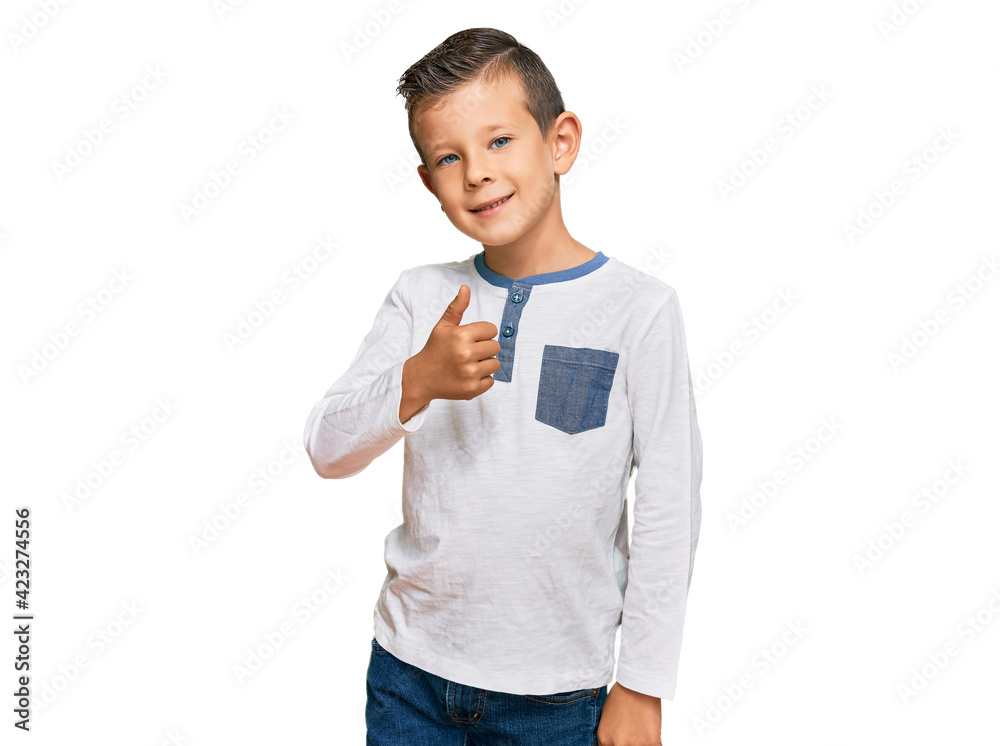 Adorable caucasian kid wearing casual clothes doing happy thumbs up gesture with hand. approving expression looking at the camera showing success. Adorable caucasian kid wearing casual clothes doing happy thumbs up gesture with hand. approving expression looking at the camera showing success.