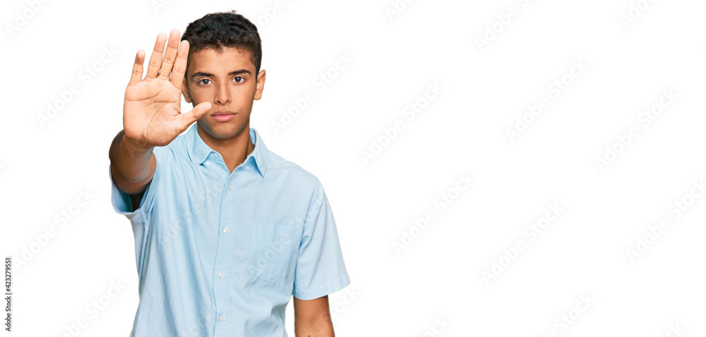 Fototapeta premium Young handsome african american man wearing casual clothes doing stop sing with palm of the hand. warning expression with negative and serious gesture on the face.