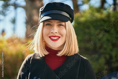 Young blonde woman smiling happy standing at the park.