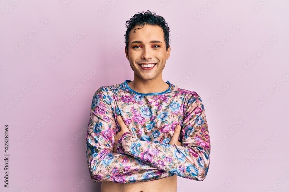 Handsome man wearing make up wearing fashion clothes happy face smiling with crossed arms looking at the camera. positive person. - obrazy, fototapety, plakaty 