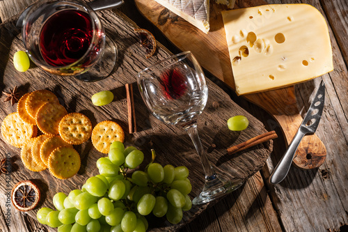 Different sorts of cheese and wine for tasting. Top view on wooden background