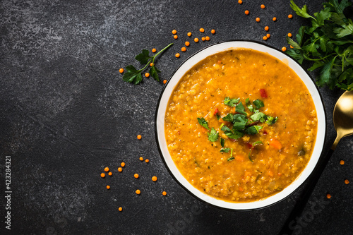 Lentil soup with vegetables on black stone table. photo