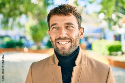 Handsome business man wearing elegant jacket smiling happy outdoors