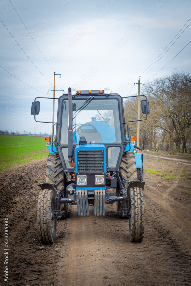 Agricultural tractor in the field. The tractor is ready to work in the field. Spring. Agricultural tractor in the field. The tractor is ready to work in the field. Spring.