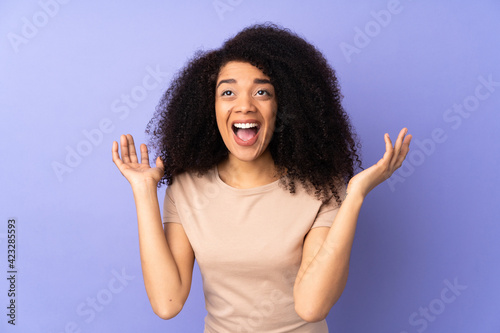 Young african american woman isolated on purple background with surprise facial expression