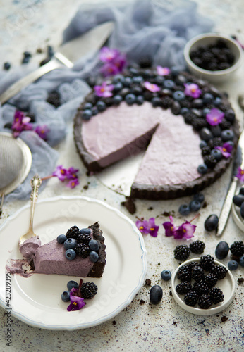 Plate with homemade piece of delicious blueberry, blackberry and grape pie or tart served on table