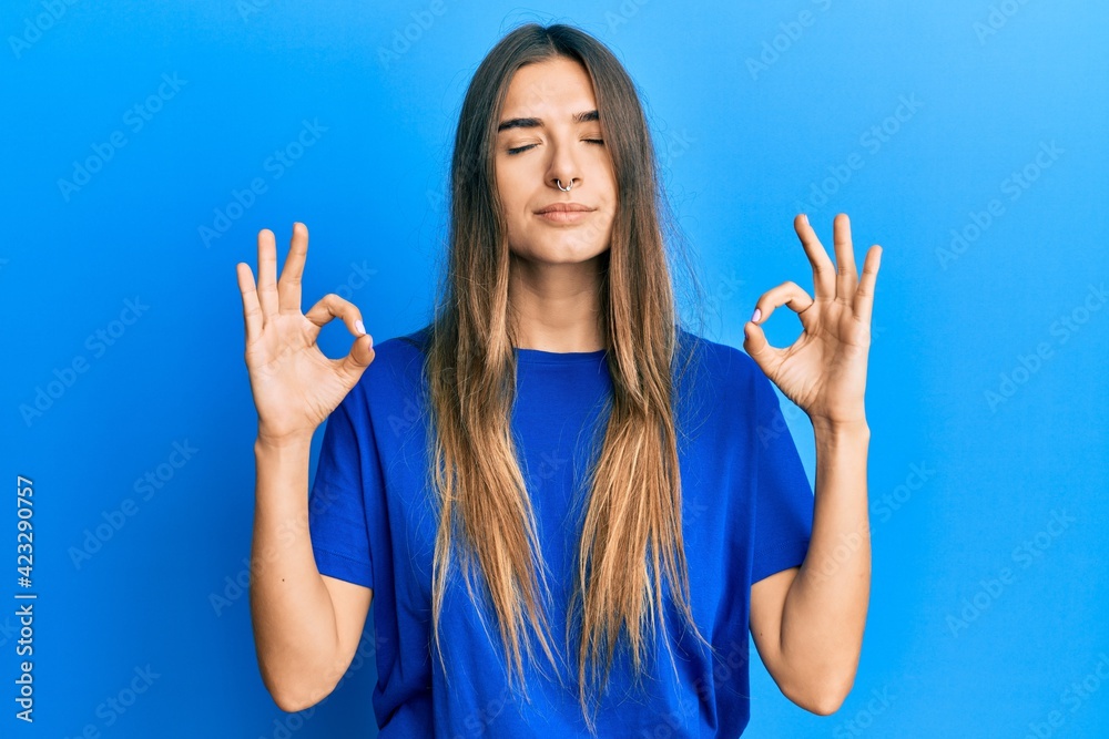 Young hispanic woman wearing casual clothes relax and smiling with eyes closed doing meditation gesture with fingers. yoga concept. Young hispanic woman wearing casual clothes relax and smiling with eyes closed doing meditation gesture with fingers. yoga concept.