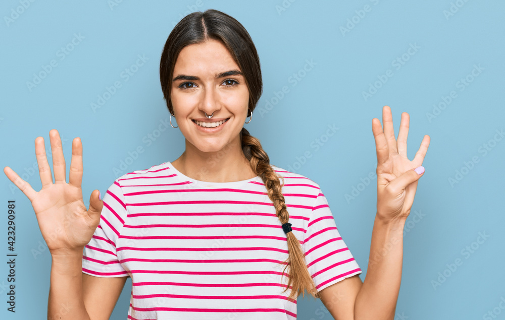 Young hispanic woman wearing casual clothes showing and pointing up with fingers number nine while smiling confident and happy. Young hispanic woman wearing casual clothes showing and pointing up with fingers number nine while smiling confident and happy.