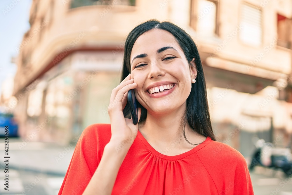 Young latin girl smiling happy talking on the smartphone at the city. Young latin girl smiling happy talking on the smartphone at the city.