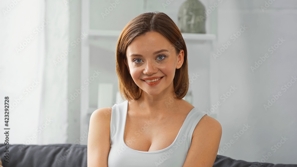 young, pretty woman smiling at camera at home