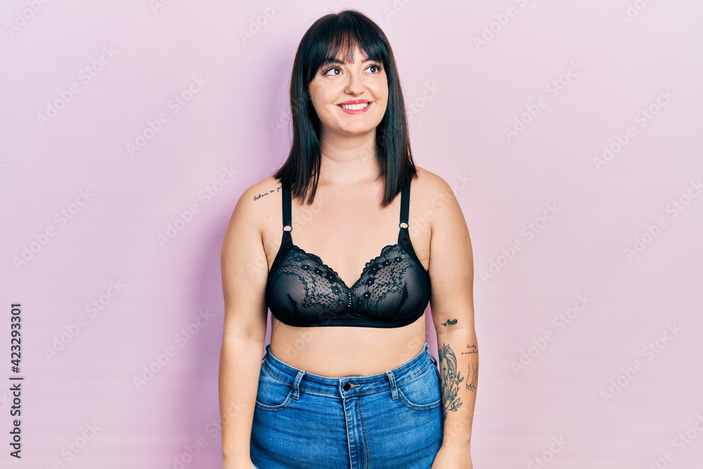 Young hispanic woman wearing lingerie looking away to side with smile on face, natural expression. laughing confident. Young hispanic woman wearing lingerie looking away to side with smile on face, natural expression. laughing confident.