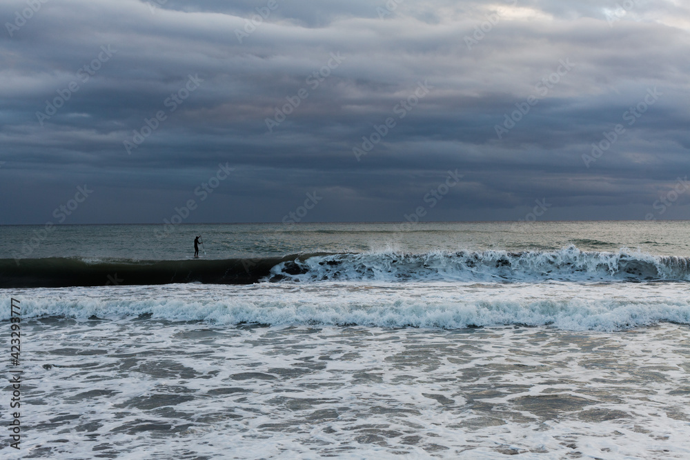 Seascape of the Mediterranean sea after a storm, surfers practicing bodyboar on the waves