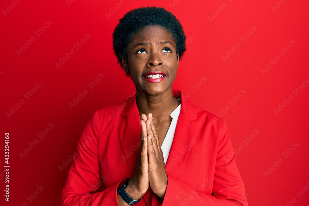 Young african american girl wearing business clothes begging and praying with hands together with hope expression on face very emotional and worried. begging. Young african american girl wearing business clothes begging and praying with hands together with hope expression on face very emotional and worried. begging.