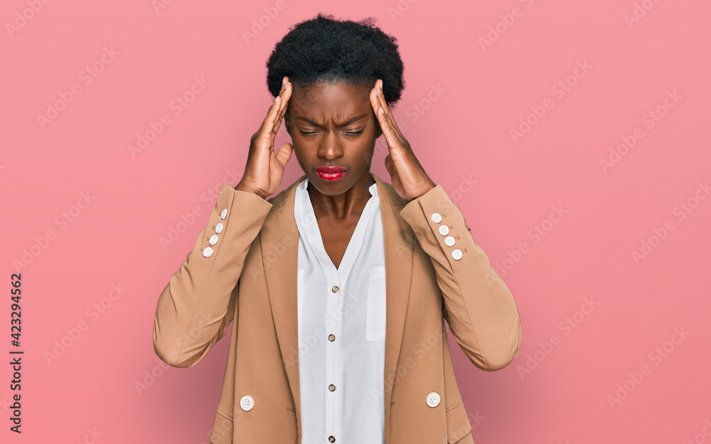 Young african american girl wearing business clothes suffering from headache desperate and stressed because pain and migraine. hands on head. Young african american girl wearing business clothes suffering from headache desperate and stressed because pain and migraine. hands on head.