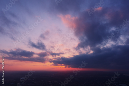 Aerial view of an orange or pink sky, a beautiful sunset, the clouds are highlighted with bright light.Evening time. © AndreyZayats