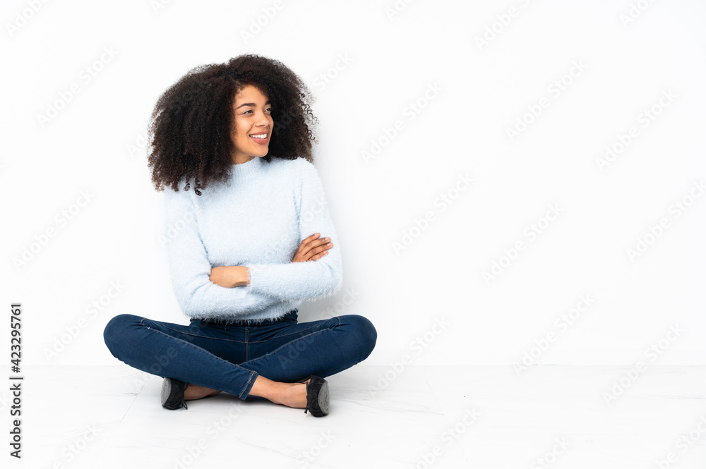 Young african american woman sitting on the floor with arms crossed and happy Young african american woman sitting on the floor with arms crossed and happy