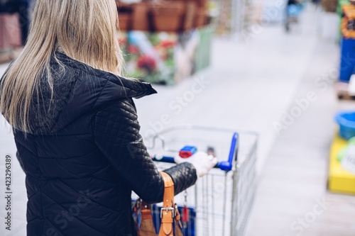 Rear view of woman shopping in supermarket during coronavirus pandemic.