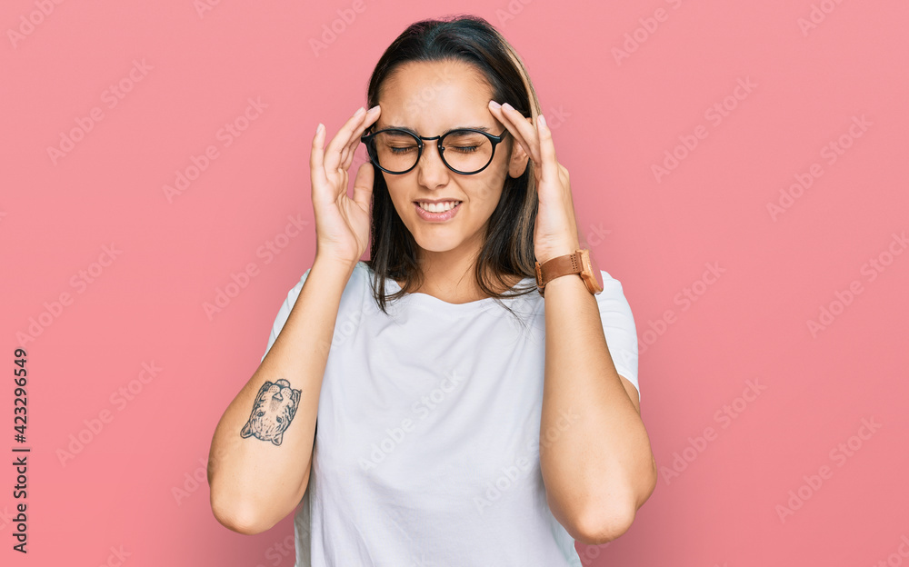 Young hispanic woman wearing casual white t shirt with hand on head, headache because stress. suffering migraine. Young hispanic woman wearing casual white t shirt with hand on head, headache because stress. suffering migraine.