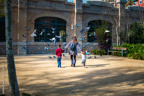 Fotografía Madre con sus hijos corriendo hacia las palomas