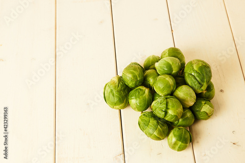 Bunch of fresh raw Brussel sprouts on a white wood table