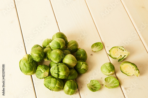 Bunch of fresh raw Brussel sprouts on a white wood table
