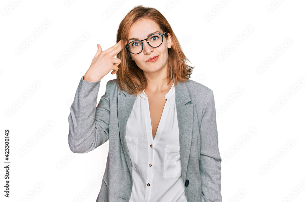 Young caucasian woman wearing business style and glasses shooting and killing oneself pointing hand and fingers to head like gun, suicide gesture. Young caucasian woman wearing business style and glasses shooting and killing oneself pointing hand and fingers to head like gun, suicide gesture.