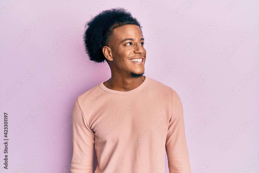 African american man with afro hair wearing casual clothes looking to side, relax profile pose with natural face and confident smile. African american man with afro hair wearing casual clothes looking to side, relax profile pose with natural face and confident smile.
