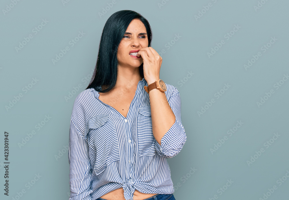Young caucasian woman wearing casual clothes looking stressed and nervous with hands on mouth biting nails. anxiety problem.