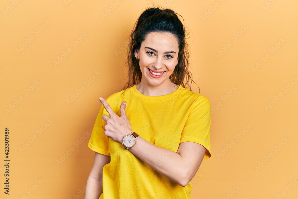 Young hispanic woman wearing casual clothes smiling cheerful pointing with hand and finger up to the side Young hispanic woman wearing casual clothes smiling cheerful pointing with hand and finger up to the side