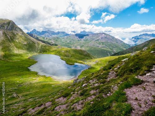 Ibón de Escalar, que es una laguna glaciar en los Pirineos españoles, muy cerca de la frontera francesa; con las grandes praderas de montaña y las altas cumbres al fondo
